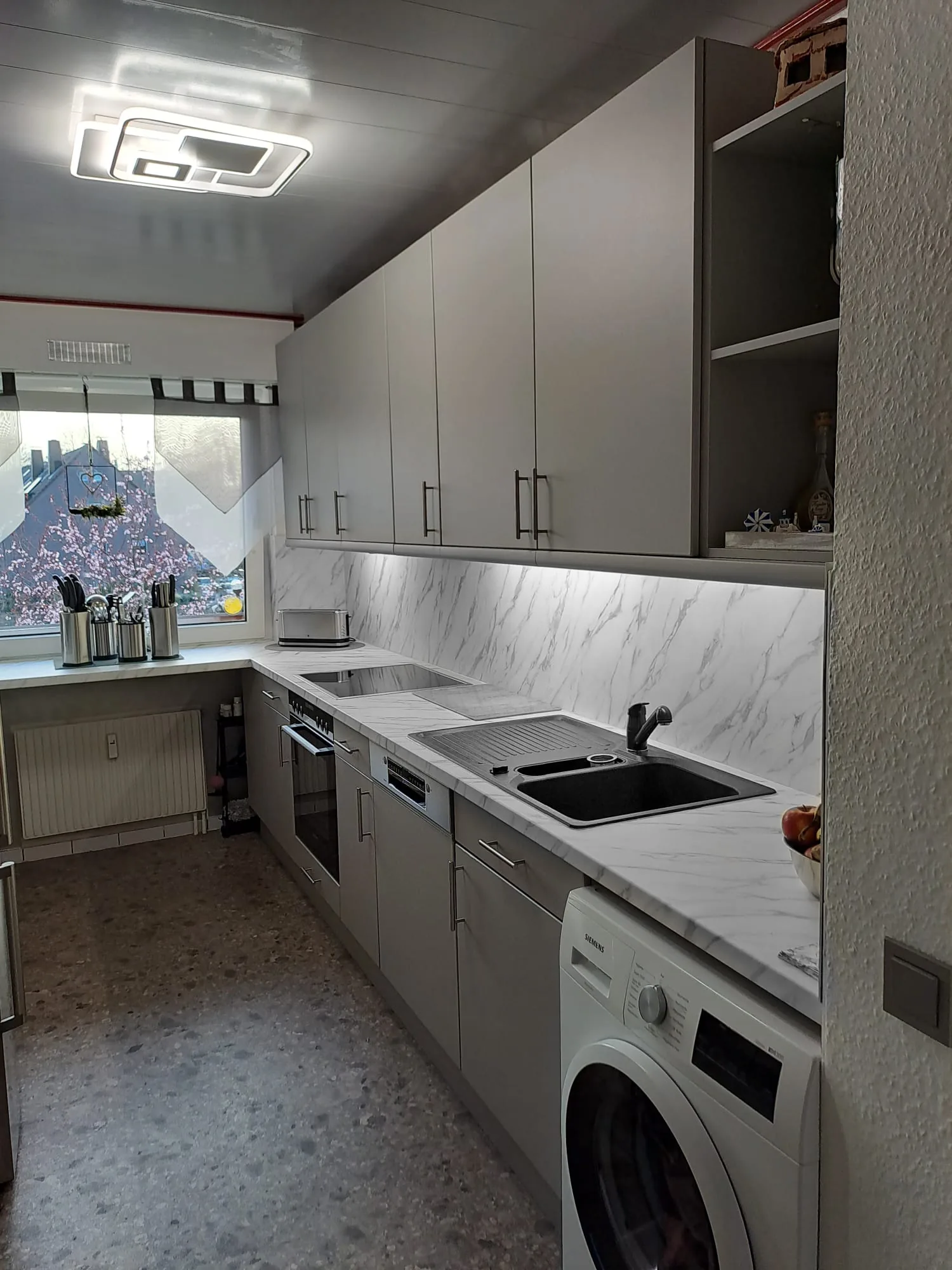 Fertige Küche nachher: Moderne graue Fronten mit Marmor-Arbeitsplatte und Rückwand