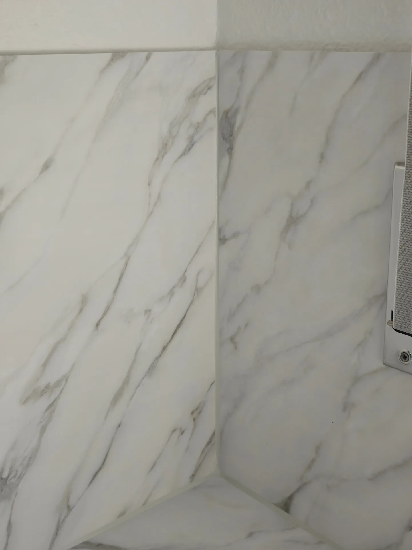 Detail der folierten Küchenrückwand in Marmor-Optik mit sauberen Übergängen